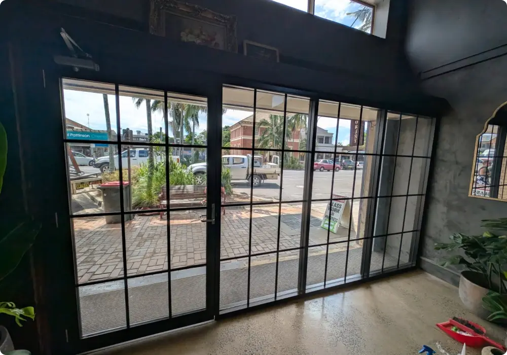 Alumalite installation team fitting commercial aluminium glazing on a Northern Rivers building site