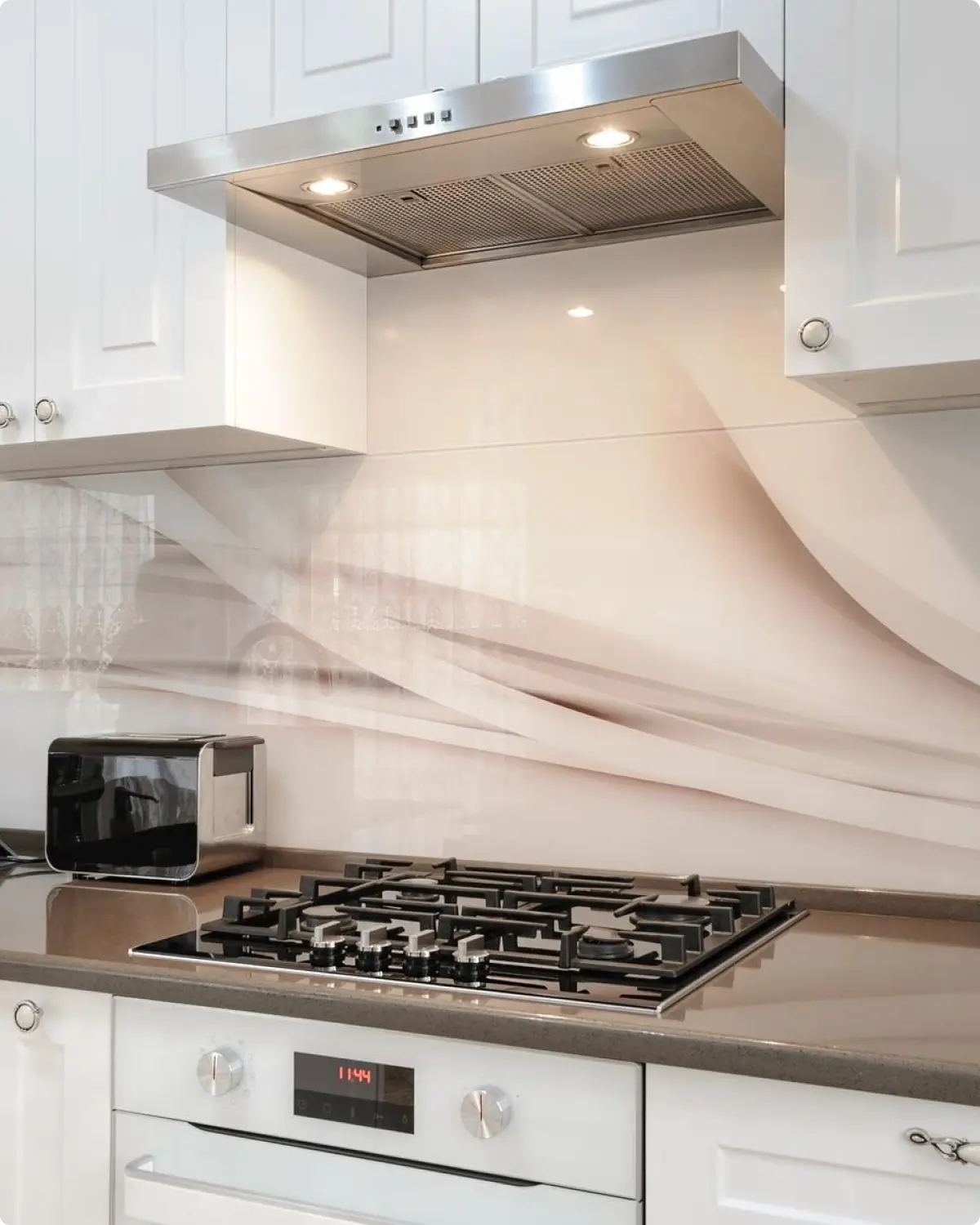 Glass splashback precision-cut to fit around power points and kitchen cabinetry