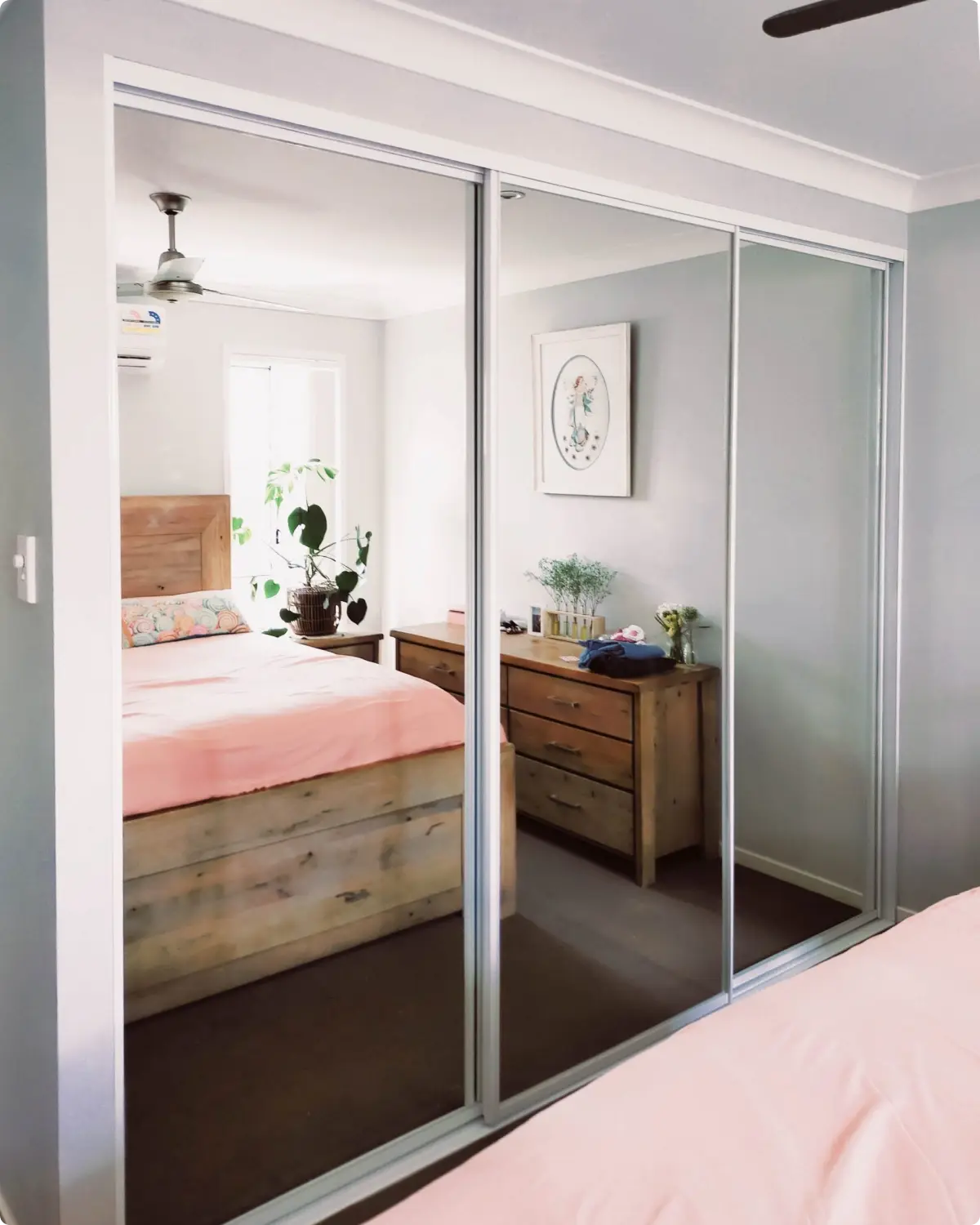 Mirrored sliding wardrobe doors reflecting light in a Northern Rivers bedroom